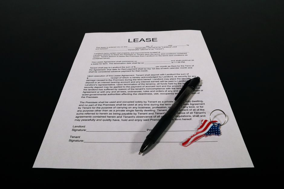 A close-up of a signed lease agreement with a set of keys resting on the paper