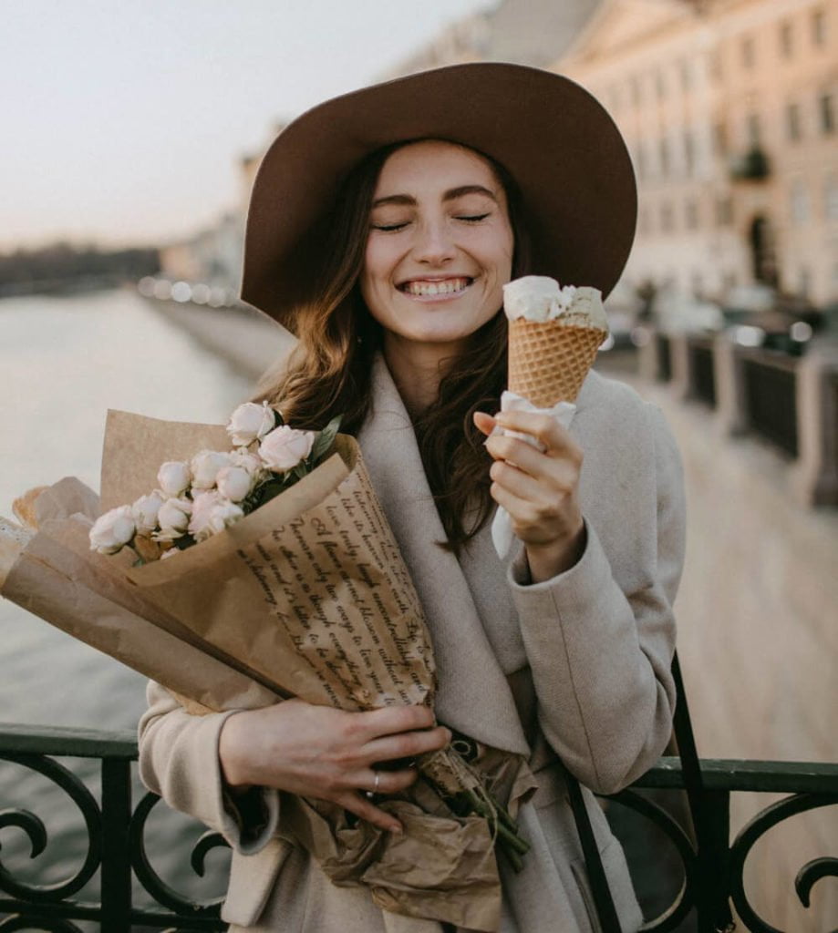 a person in a hat holding a bag of popcorn