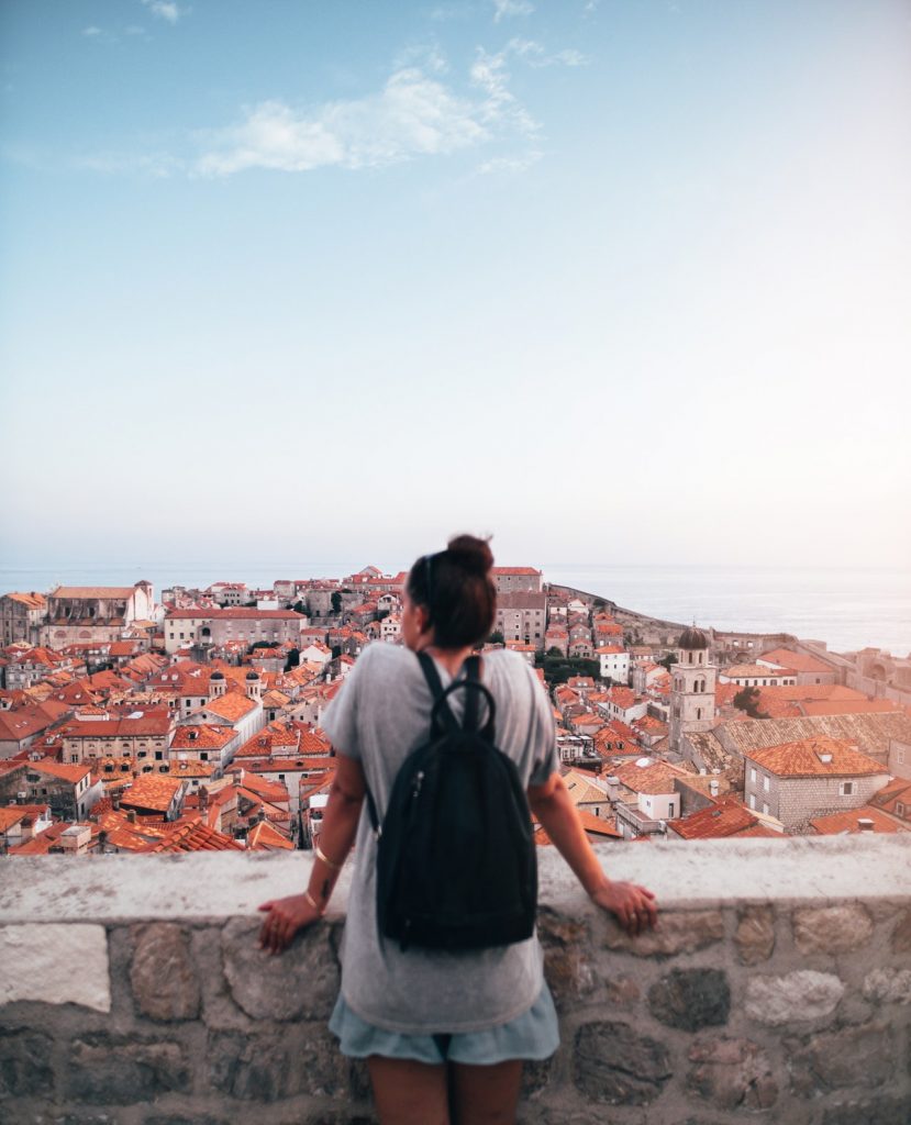 a man standing on a ledge overlooking a city